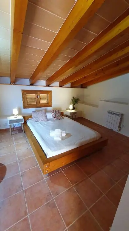 Schlafzimmer mit Holzbalken und Terrakottaboden