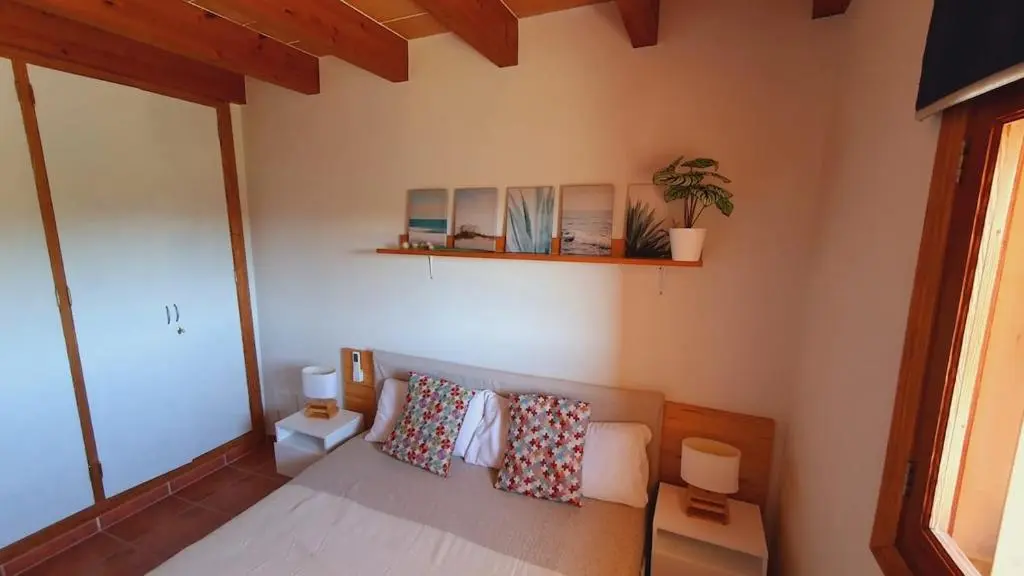 Schlafzimmer mit rustikalen Balken und Dekokissen