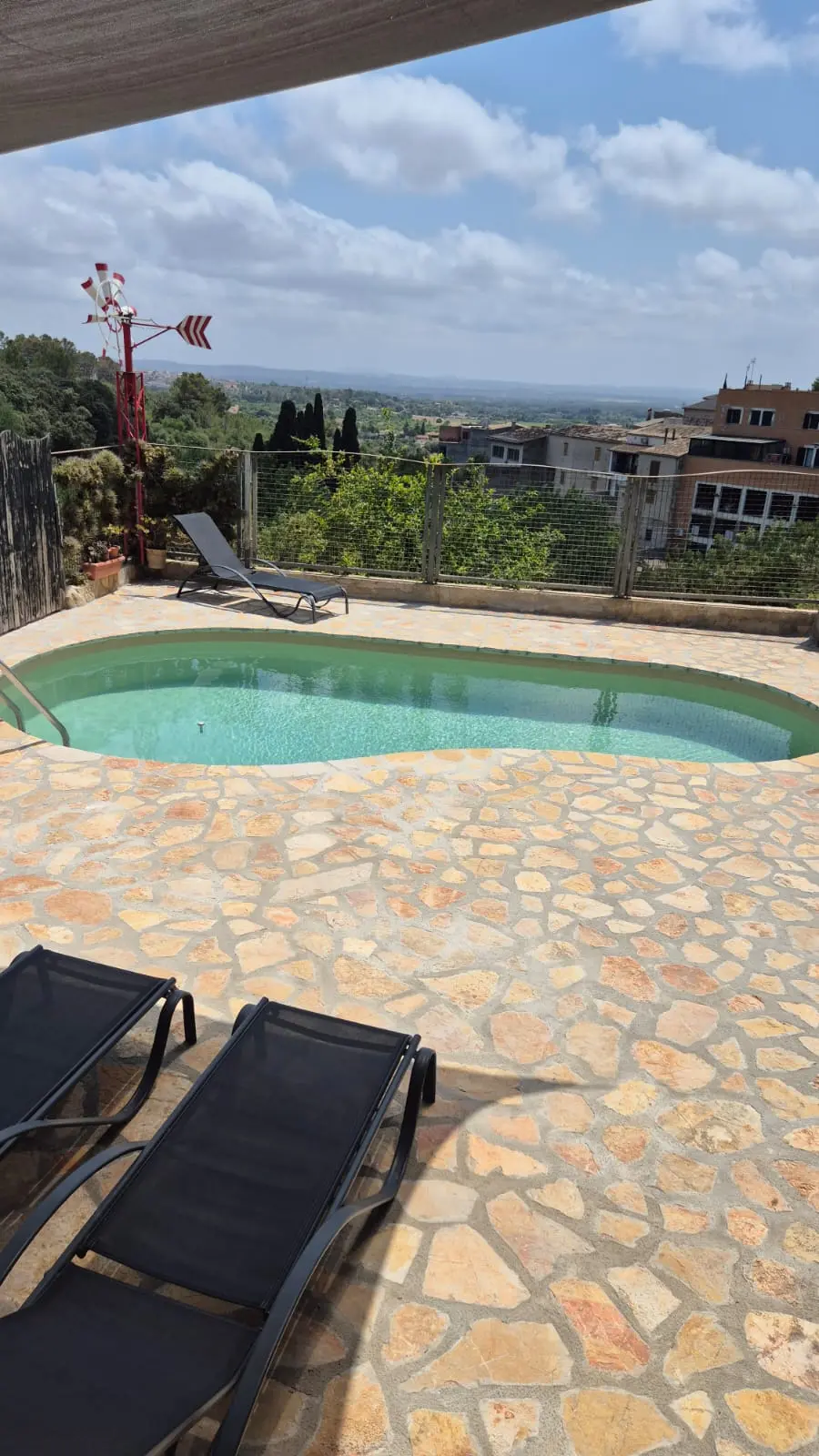 Pool mit Liegestühlen und Landschaftsblick